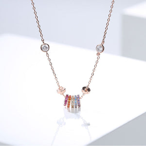 Rose gold necklace with a fine chain, featuring a cluster of colorful crystal rings and two clear crystal accents.