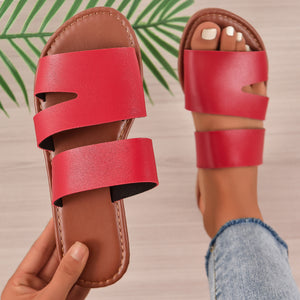 Red open toe flat sandals with two wide straps and a cut-out detail.