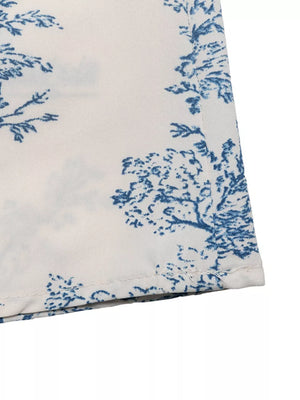 Midi dress with blue toile print on white fabric, V-neck, a-line cut.