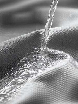Gray pet carrier fabric repelling water, showing breathable material.