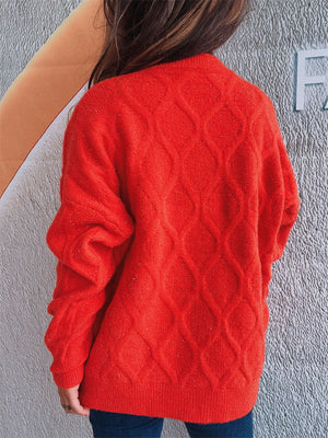 Orange-red sparkle knit sweater with diamond cable knit pattern and relaxed fit.