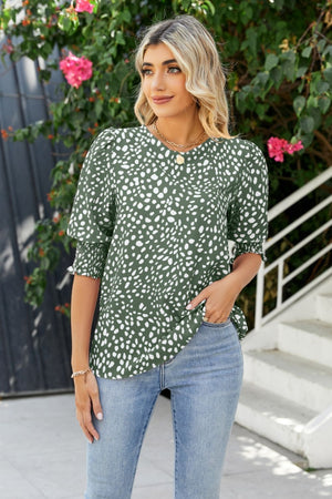 Green spot print blouse with shirred short sleeves and a V-neck.