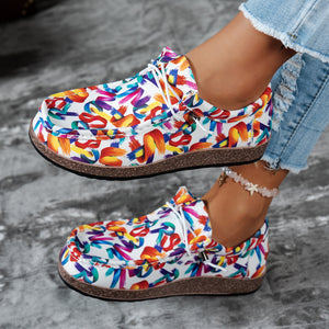 Printed casual slip-on loafers with abstract brushstroke pattern in white and multicolor.