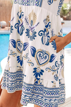 White floral print mini dress with ruffled hem and sleeves, featuring blue and gold bohemian pattern.