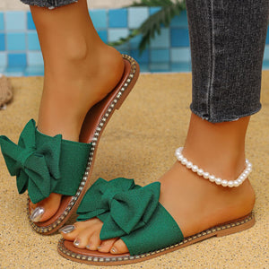 Green bowknot slide sandals with studded trim.