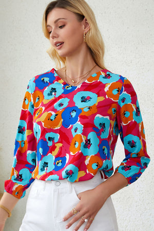 Painterly floral print blouse in pink with blue, orange, and yellow blossoms, V-neck, 3/4 sleeves.