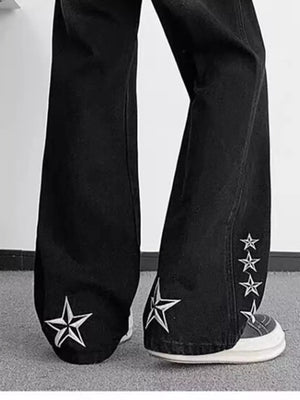 Black wide-leg jeans with embroidered white stars on the legs.