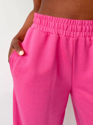 Wide-leg lounge pants in hot pink with an elastic waistband and pockets.