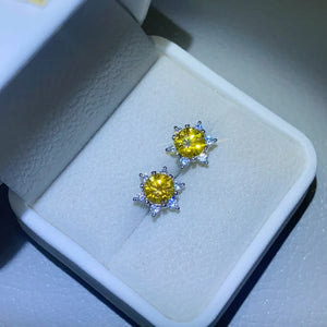 Golden sunburst moissanite stud earrings in silver with sparkling accents.