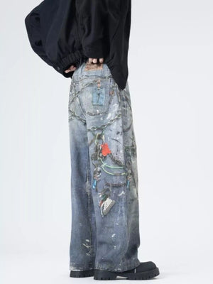 Men's wide-leg jeans in dusty blue denim with chain and keychain print details.