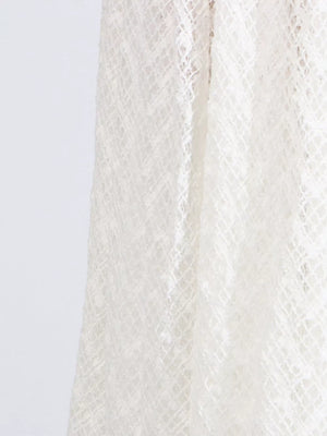 White lace maxi dress detail showing intricate diamond pattern fabric.