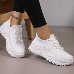 White knit sneakers with textured chunky sole and lace-up closure.