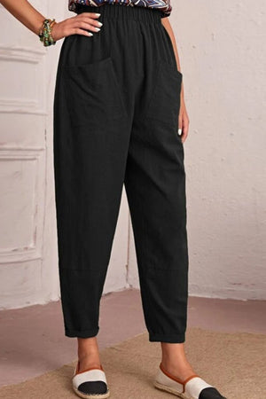 Black linen tapered trousers with elastic waist and large front pockets.