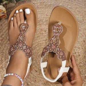 Bohemian beaded sandals in off-white with intricate bronze and red beadwork on straps and ankle strap.
