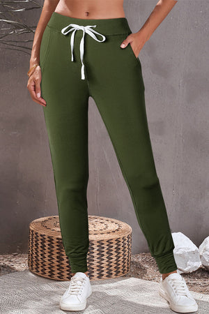 Slim-fit army green joggers with white drawstring and pockets