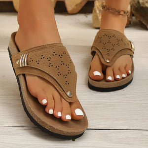 Brown hollow-out toe-post sandals with cork-style sole and adjustable ankle strap.