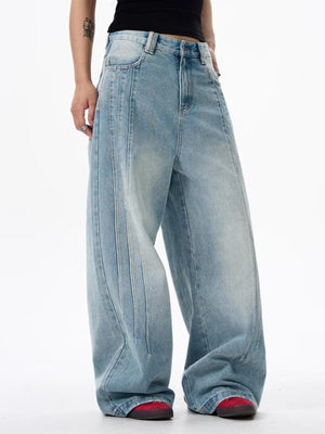 Men's light blue washed denim wide leg jeans with vertical seam details.