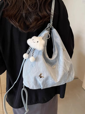 Light blue shoulder bag with butterfly appliques and a cloud charm.