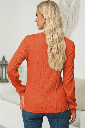 Textured wave crewneck pullover in orange with long sleeves and a casual fit.