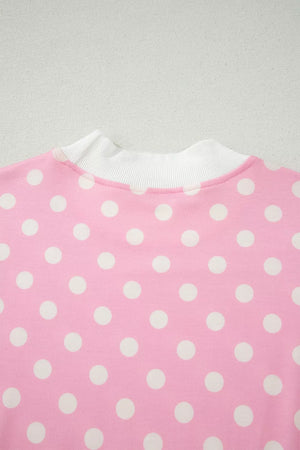 Pink polka dot top with white ribbed mock neck detail