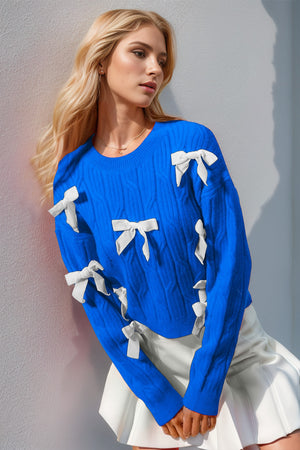 Blue cable knit sweater with white bow embellishments and crew neck