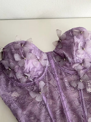 Purple lace bustier top with 3D butterflies and bow details.