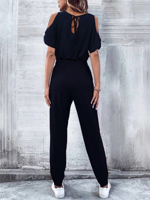 Dark blue cold-shoulder jumpsuit with drawstring waist and tie back detail.