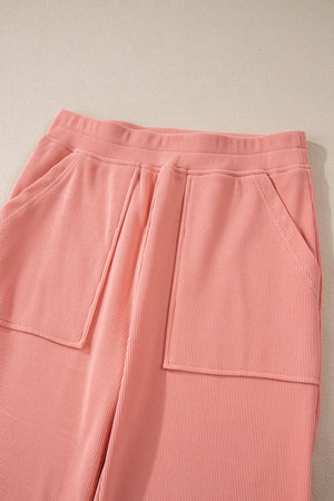 Pink corduroy lounge pants with relaxed fit and patch pockets.