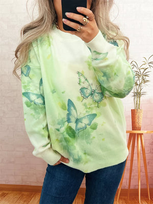 Lightweight knit sweater with allover green watercolor butterfly print and crystal details.