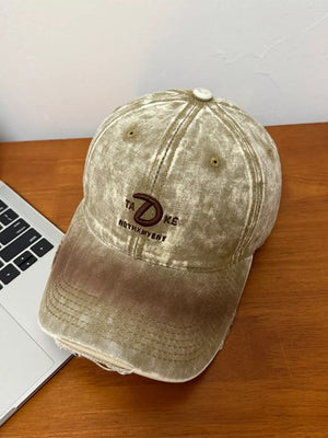 Khaki vintage denim baseball cap with embroidered logo and distressed details.