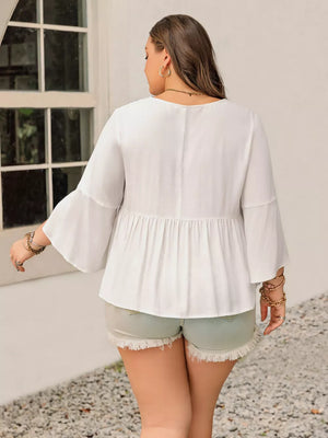 Plus size white peasant blouse with bell sleeves and tiered hem.