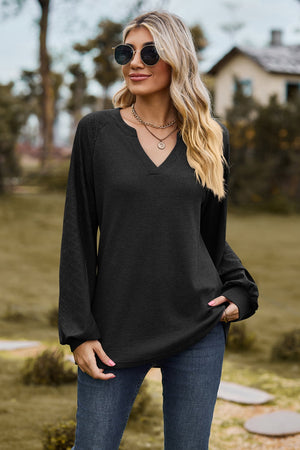 Black waffle knit raglan sweater with laser cut sleeves and v-neck