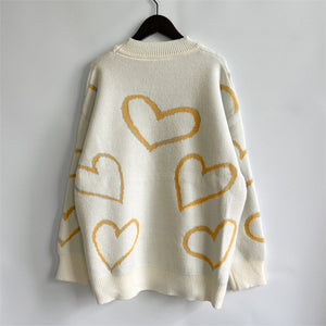 Cream acrylic knit sweater with yellow heart outline pattern and mock neck.