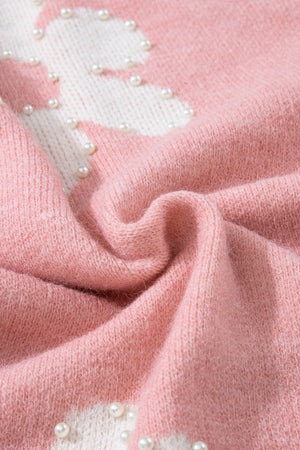 Blush pink knit sweater with white floral pattern and pearl embellishments.