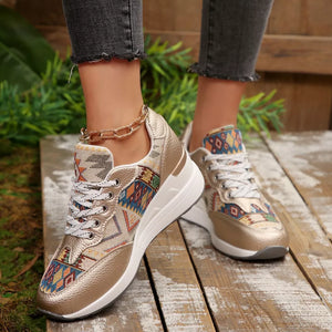 Gold wedge sneakers with geometric pattern and chunky sole.