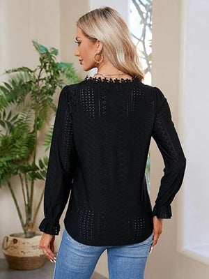 Black eyelet blouse with floral embroidery and ruffle cuffs.