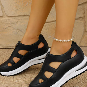 Black cutout wedge sneakers with zipper detail and chunky white sole.