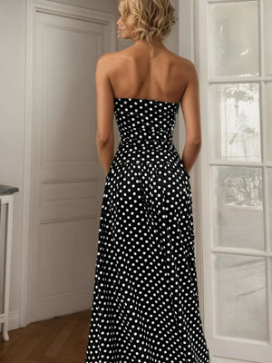 Black polka dot strapless maxi dress with a cinched waist and flowing skirt.