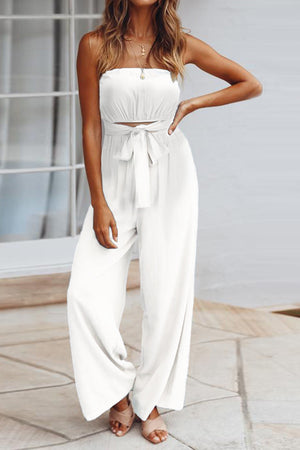 White bandeau tie-waist wide-leg jumpsuit with a cropped bodice and flowy pants.