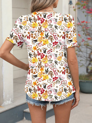 Women's white short sleeve blouse with vibrant floral print.