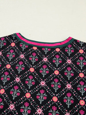Black cotton blouse with vintage floral pattern and contrast neckline trim.
