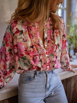 Frill trim button-up shirt with a pink floral print and long sleeves.