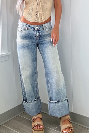 Medium washed denim trousers with cuffed hems and a relaxed fit.