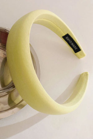 Light Yellow padded headband with textured fabric and a black "HAND MADE" tag.