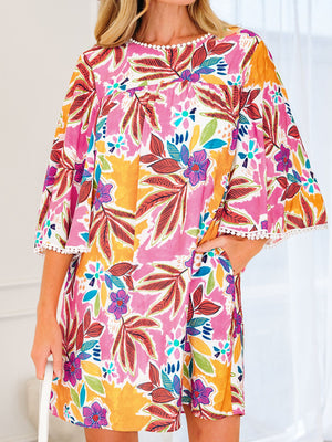 Print bell sleeve mini dress with colorful floral pattern and pom-pom trim.