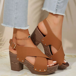 Brown crisscross high heel sandals with studs and adjustable ankle strap.