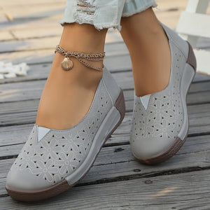 Grey floral cutout slip-on loafers with a seashell anklet.