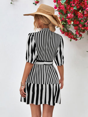 Black and white vertical stripe shirred waist dress with puff sleeves and a belted A-line skirt.