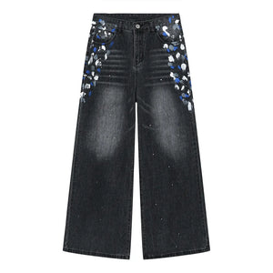 Dark wash wide leg jeans with painterly brushstroke details on pockets and legs.