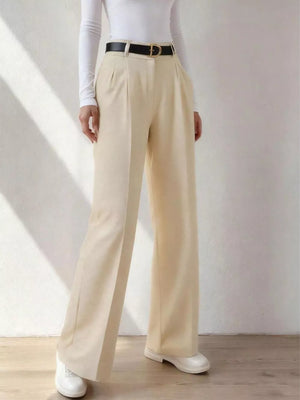 Beige wide-leg dress pants with pockets, belt loops, and a pleated front, styled with a black belt.